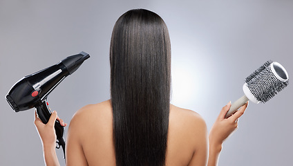 Image showing Volume or no volume. Rearview shot of a woman with sleek hair holding a hairdryer and blow-dry brush.