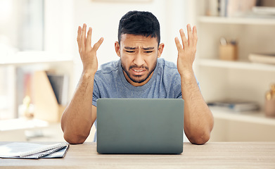 Image showing What is going on. a young businessman looking confused while using a laptop at work.