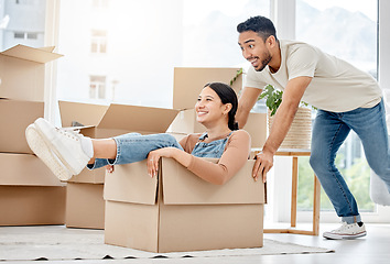 Image showing Get ready for a cruise around your new home. a young couple playing with boxes while moving house.