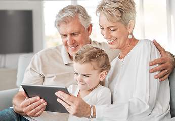 Image showing Family means no one gets left behind. an adorable little girl using a digital tablet while sitting at home with her grandparents.