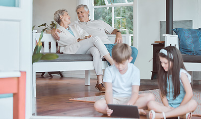 Image showing Babysitting made easy. a brother and sister bonding while using a digital tablet together with their grandparents in the background.