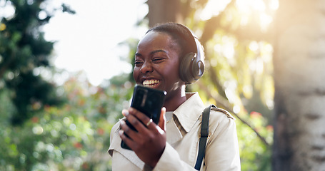 Image showing Smile, phone and woman with headphones for fun, funny and podcast or song, energy and relax in outdoors. Black female person, streaming radio and music or audio, nature and internet on smartphone