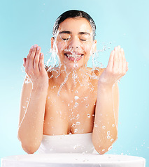 Image showing All I want is world peace and beautiful skin. a young woman doing her daily skincare routine against a blue background.