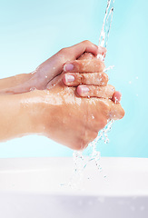 Image showing May your day be as flawless as your skin. an unrecognizable woman washing her hands against a blue background.