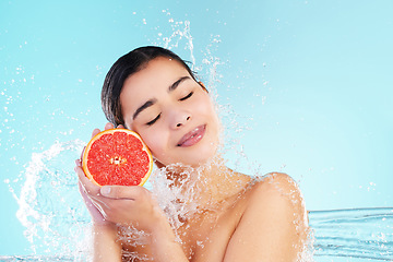 Image showing It’s a SKIN-vestment. Studio portrait of an attractive young woman posing with a grapefruit in her hand against a blue background.