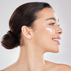 Image showing Just one swipe. a young woman applying a cream to her face against a grey background.