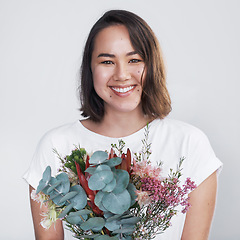 Image showing Getting a floral arrangement from a significant other will make anyones day. a beautiful young woman posing with a bouquet against a white background.