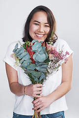 Image showing Theres no better way to show your love than with flowers. a beautiful young woman posing with a bouquet against a white background.