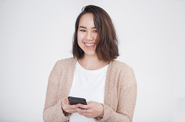 Image showing What should I text back. a beautiful young woman posing against a grey background.