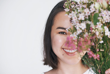 Image showing Every woman deserves to be delighted by flowers. a beautiful young woman posing with a bouquet against a white background.