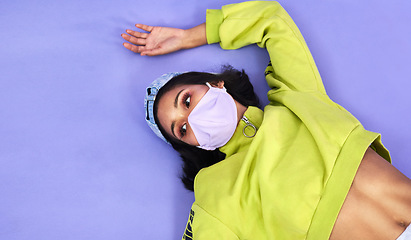 Image showing Safety is so in fashion right now. Studio shot of a beautiful young woman wearing a face mask against a purple background.