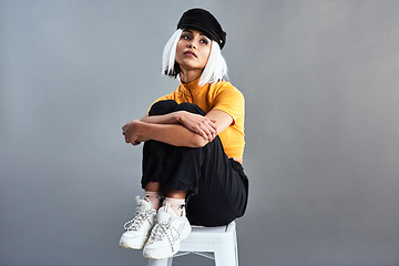 Image showing Unique style is everlasting style. Studio shot of a beautiful young woman sitting on a stool against a grey background.