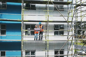 Image showing Designing and signing off on contracts. a young man and woman going over building plans at a construction site.