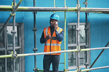 Image showing Monitoring the flow of a new build. a young man talking on a cellphone while working at a construction site.