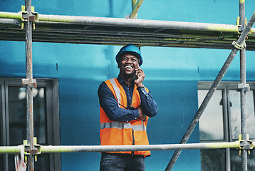 Image showing Staying connected to the rest of his team. a young man talking on a cellphone while working at a construction site.