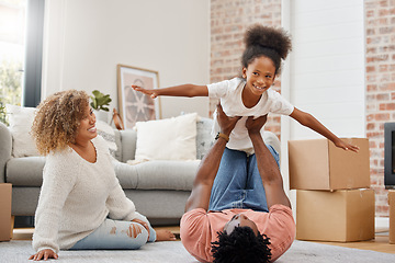 Image showing Were always having fun. a young dad holding his daughter up in the air with his arms and legs at home.