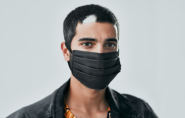 Image showing Safety is always in style. Studio shot of a masked young man posing against a grey background.