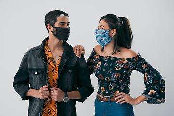 Image showing Face masks just upped our fashion game. Studio shot of a masked young man and woman posing against a grey background.