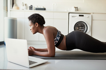 Image showing Plank your way to a tighter tummy. a young woman using a laptop while exercising at home.
