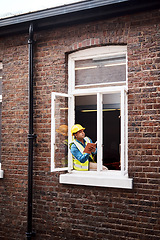 Image showing We can definitely expand this window. a engineer making notes while looking out the window of a construction site.