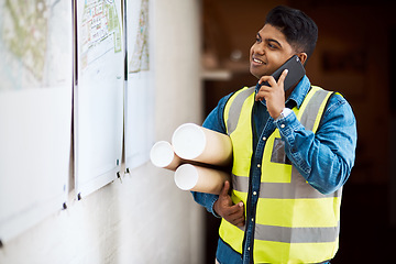 Image showing This is a big project, Ill need everyone on it. a young engineer talking on his cellphone while reading something on a wall.