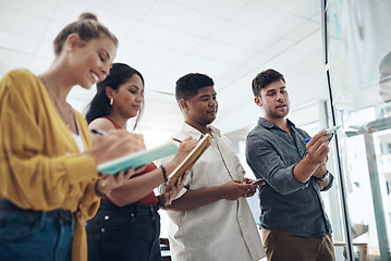 Image showing Finalising a new creative campaign. a group of businesspeople brainstorming with notes on a glass wall in an office.