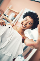 Image showing Im back with some more fashion tips. a woman holding up a shirt towards the camera.