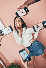 Image showing Everyone wants to know her secret. a beautiful young woman having her picture taken on multiple phones.