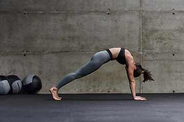 Image showing Fit woman in a modern gym working flexibility and strength through various exercises, demonstrating her commitment to fitness