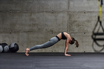 Image showing Fit woman in a modern gym working flexibility and strength through various exercises, demonstrating her commitment to fitness