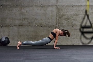 Image showing Fit woman in a modern gym working flexibility and strength through various exercises, demonstrating her commitment to fitness