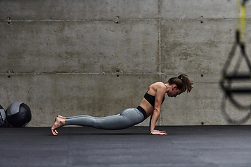 Image showing Fit woman in a modern gym working flexibility and strength through various exercises, demonstrating her commitment to fitness