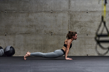 Image showing Fit woman in a modern gym working flexibility and strength through various exercises, demonstrating her commitment to fitness