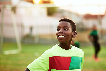 Image showing Playing a sport is a great way for kids to loosen up. a young boy playing soccer on a sports field.