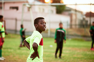 Image showing The future looks bright for this young soccer star. a young boy playing soccer on a sports field.