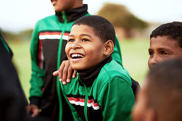 Image showing When it comes to soccer, his eyes always sparkle with excitement. a young boy standing alongside his soccer team on a sports field.