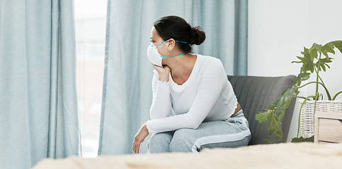 Image showing Theres so much I want to do when its all over. a young woman wearing a mask while looking out a window at home.