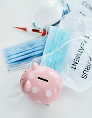 Image showing This pandemic has everyone digging into their savings. a piggybank and coronavirus props against a white background.