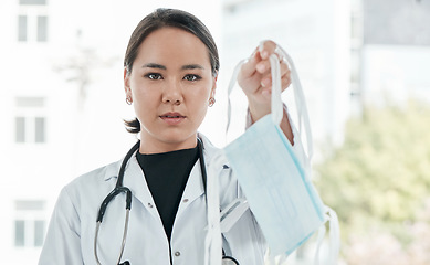 Image showing A face mask a day, keeps the doctor away. a medical practitioner holding up a face mask.