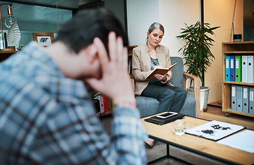 Image showing Buried emotions eventually come back. a young man having a therapeutic session with a psychologist and looking upset.