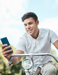 Image showing Mobile tech keeps him moving. a young businessman using a smartphone while riding his bicycle in the city.