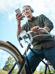 Image showing To make things happen youve got to stay mobile. a young businessman using a smartphone while riding his bicycle in the city.