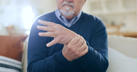 Image showing Home, injury and senior man with wrist pain, bruise or inflammation with muscle tension in a lounge. Pensioner, old person and elderly guy on a sofa, accident or emergency with arthritis or broken