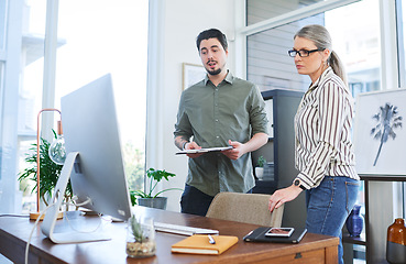 Image showing Deciding on which plans to proceed with. two businesspeople working together on a computer in an office.