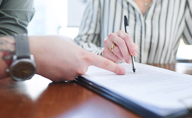 Image showing Going over the fine print. Closeup shot of two unrecognisable businesspeople going through paperwork together in an office.