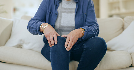 Image showing Home, injury and senior woman with knee pain, massage and inflammation in a living room. Pensioner, old person and elderly lady on a couch, accident or emergency with bruise, broken or muscle tension