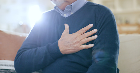 Image showing Hand, chest and heart attack with a senior man closeup on a sofa in the living room of his home during retirement. Healthcare, medical and cardiovascular disease with an elderly person in pain