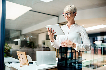 Image showing I can always rely on my device to get the job done. a pregnant businesswoman using a digital tablet in an office.