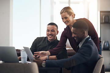 Image showing Providing input to perfect their plan. a group of businesspeople working together on a laptop in an office.