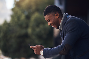 Image showing Business has been good. a young businessman using a cellphone while standing on the balcony of an office.